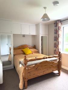 布莱辛顿Tully's Home, Tulfarris Village, Wicklow的一间卧室配有一张带黄色枕头的木床
