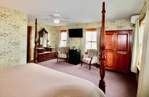 新肖雷汉姆Rose Farm Inn的卧室配有一张床、一张桌子和椅子
