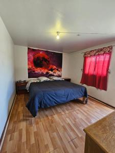 科皮亚波el valle的卧室配有一张床,墙上挂有绘画作品
