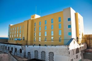Apizaco阿皮萨科城市快捷酒店的一座大型黄色建筑,位于一座建筑的顶部