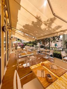 圣玛格丽塔-利古雷阿尼塔别墅酒店的庭院内的餐厅,配有桌椅