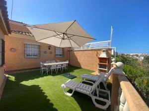 马塔拉斯卡尼亚斯Casa Doñana Golf的庭院配有桌椅和遮阳伞。