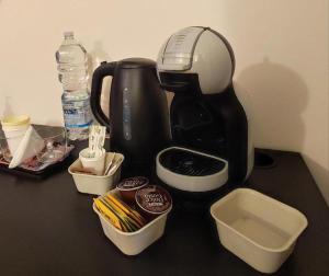 米兰il Sole di Baggio的一张桌子上装有容器的黑色咖啡壶