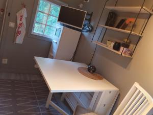 诺尔泰利耶Norrtälje的配有冰箱的客房内的白色书桌