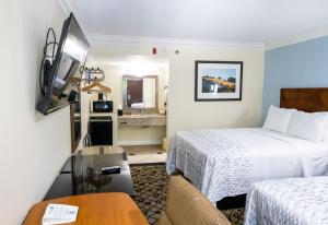 亚特兰大Baymont by Wyndham College Park Atlanta Airport South的酒店客房设有两张床和一张桌子。