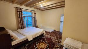 罕萨Karakorum Family Guest House Hunza的一间小卧室,配有床和窗户