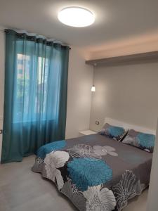 热那亚La Casa di Linda的一间卧室配有一张带蓝色窗帘的床和一扇窗户
