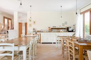 马尔孔艾卡皮尼农庄的厨房以及带木桌和椅子的用餐室。