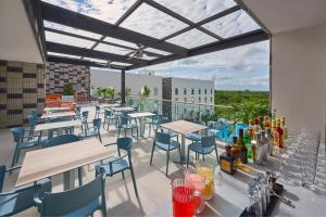 坎昆City Express Plus by Marriott Cancun Aeropuerto Riviera的阳台的天井配有桌椅