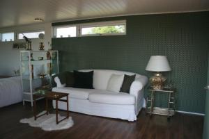 HorbelövFalsterly Glamping的客厅设有白色沙发和绿色墙壁。