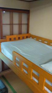 盛冈Female Only Dormitory 4beds room- Vacation STAY 14308v的一间卧室配有一张带蓝色床单的木床。