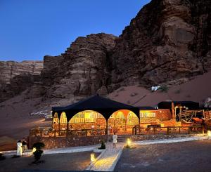 瓦迪拉姆Desert Magic Camp & Resort的夜晚在山前的帐篷