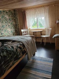 阿卢克斯内Laivu māja uz Alūksnes ezera/ Boat house on a Lake的卧室配有一张床和一张桌子及椅子