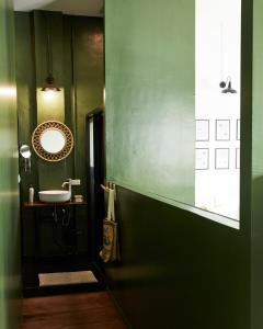 曼谷Motu Bangkok的绿色浴室设有水槽和镜子