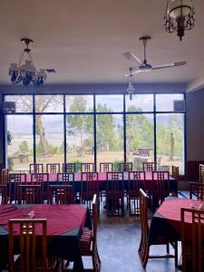 MingoraRock City Resort的一间带桌椅的用餐室和大窗户