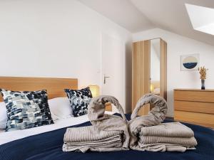 布西圣乔治Akela - Appartement à 12mn de Disneyland Paris !的一间卧室,床上配有两条毛巾天鹅