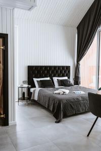 马多纳Sniegi design cabin with sauna的一间卧室配有一张大床和黑色床头板