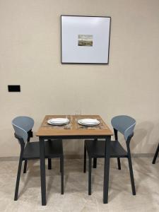 梅利德URBAN Pensión的一张带椅子的木桌和墙上的照片