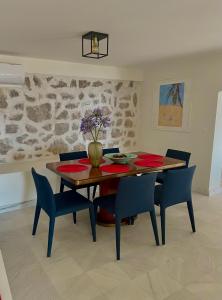 布德瓦Villa Portico的一间带木桌和蓝色椅子的用餐室
