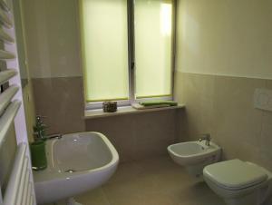 博尔扎诺Jolli Mountain的一间带水槽和卫生间的浴室以及两个窗户。