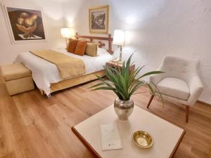 利马Antara Hotel & Suites - Miraflores的卧室配有1张床、1张桌子和1把椅子