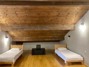 梅斯蒂亚AlpHouseApartment Mestia的配有木天花板的客房内的两张床