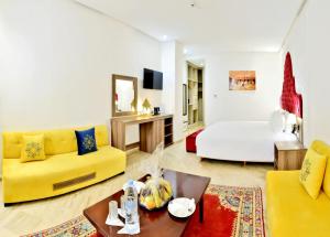 非斯Fes Heritage Boutique luxury Hotel的客厅配有黄色的沙发和床。