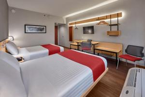 圣路易斯波托西圣路易斯波多西大学区城市快捷酒店的酒店客房配有两张床和一张书桌