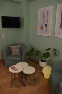 哈尔基斯ΆLthea Apartment的客厅配有两张桌子和一张沙发
