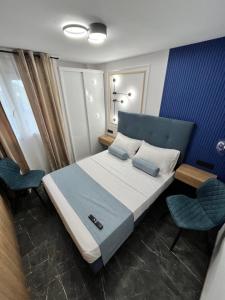 阿利坎特Elegante Apartamento TRES COLORES的一间卧室配有一张床和两把椅子