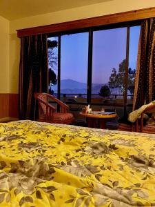 MingoraRock City Resort的一间卧室配有一张黄色棉被的床