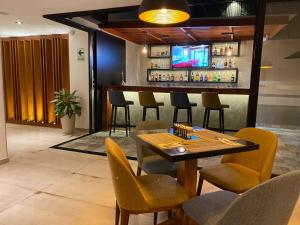 皮乌拉Grau Business Hotel的餐厅设有酒吧,配有椅子和桌子