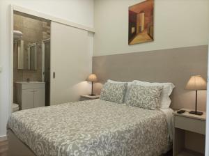 波尔图HOSPEDARIA LONDRES的一间卧室配有一张大床和两盏灯。