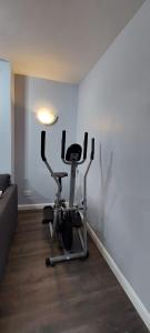 伦敦One Bedroom Flat In Finchley Road的客厅设有健身房和健身自行车