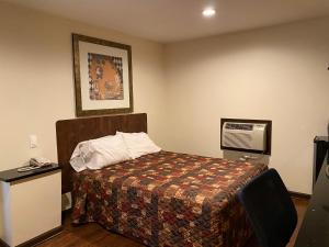 索尔兹伯里预算酒店的酒店客房设有一张床,墙上挂着一张照片