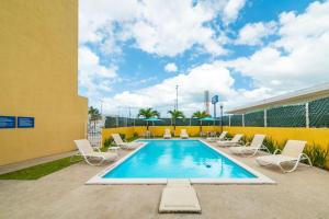 帕拉伊索City Express by Marriott Paraiso的一个带躺椅的游泳池和一个游泳池