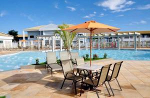 卡达斯诺瓦斯Lacqua Diroma - parque 24H的游泳池旁配有遮阳伞的桌椅