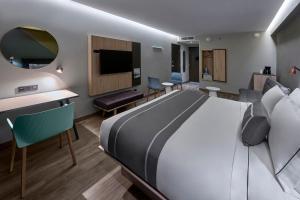 恩塞纳达港City Express Plus by Marriott Ensenada的一间带大床的卧室和一间客厅
