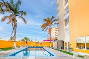 卡门城卡门城市快捷酒店的一座棕榈树游泳池和一座建筑