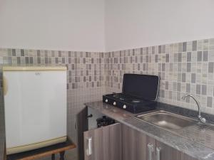 得土安Complexe tamuda doha tetouan的厨房配有水槽和台面上的笔记本电脑