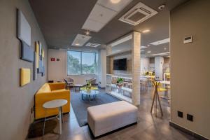 瓜达拉哈拉City Express Plus by Marriott Guadalajara Palomar的客厅配有黄色的沙发和桌子