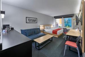 提华纳提华纳里约城市快捷酒店的酒店客房配有床、沙发和桌子。