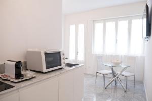 维亚雷焦Althea的白色的厨房配有电视和桌子。