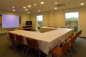 马萨特兰City Express by Marriott Mazatlan的一间会议室,配有桌椅和投影屏幕