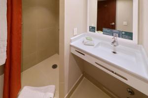 提华纳City Express Junior by Marriott Tijuana Otay的一间带水槽和淋浴的浴室