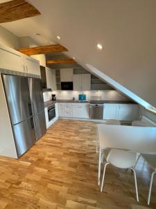 斯德哥尔摩Home Inn HVG54的厨房配有白色橱柜、桌子和冰箱。