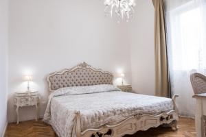 维亚雷焦Althea的一间卧室配有一张带白色床罩和吊灯的床。