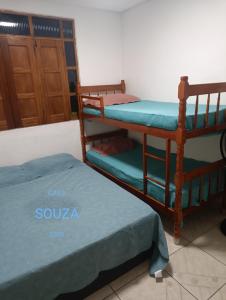 伊列乌斯Casa Souza的带两张双层床和一扇门的房间