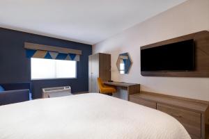 摩押摩押套房快捷假日酒店的一间卧室配有一张床和一台平面电视
