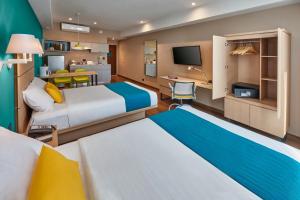 提华纳City Express Suites by Marriott Tijuana Rio的酒店客房配有两张床和一张书桌